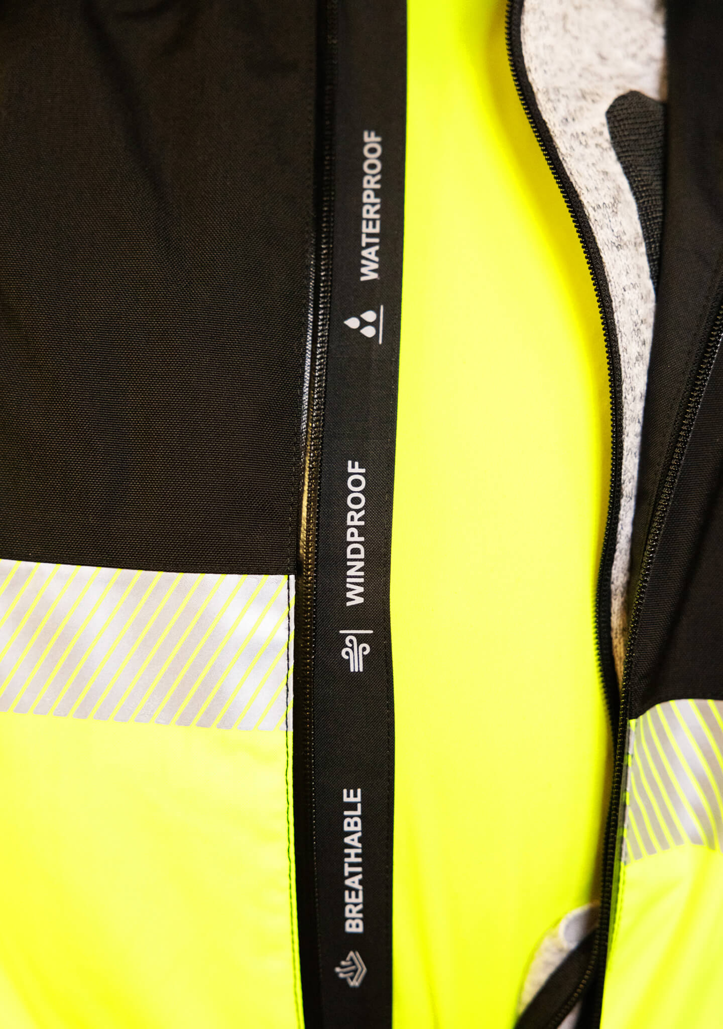 Die wind- und wasserdichte Regenjacke RIFFGAT in neongelb oder schwarz eignet sich perfekt für Industriekletterer und alle anderen, die im Bereich der Höhenarbeit mit Seilzugangstechnik arbeiten. (Ansicht Nahaufnahme FEATURES))