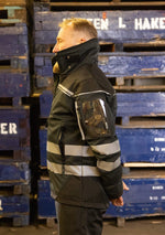 Laden Sie das Bild in den Galerie-Viewer, Hier ist eine Softshelljacke abgebildet, die winddicht und wasserabweisend ist. Eine durchdachte Taschenplatzierung ermöglicht das Tragen der Jacke im Klettergurt beim Industrieklettern in der Höhe (Ansicht links)
