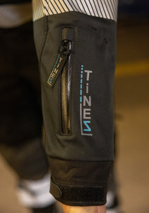 Hier ist eine Softshelljacke abgebildet, die winddicht und wasserabweisend ist. Eine durchdachte Taschenplatzierung ermöglicht das Tragen der Jacke im Klettergurt beim Industrieklettern in der Höhe (Ansicht Nahaufnahme Ärmeltasche))